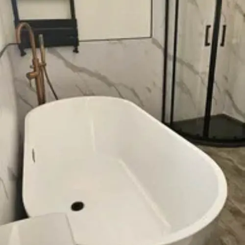 Freestanding bath next to a black shower enclosure in a renovated Cardiff bathroom