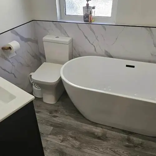 Freestanding bath with brushed brass taps and vanity basin in Cardiff
