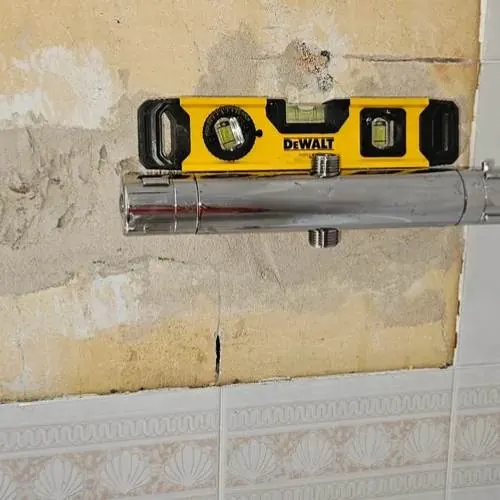 Thermostatic bar shower valve being levelled during fitting in Cardiff